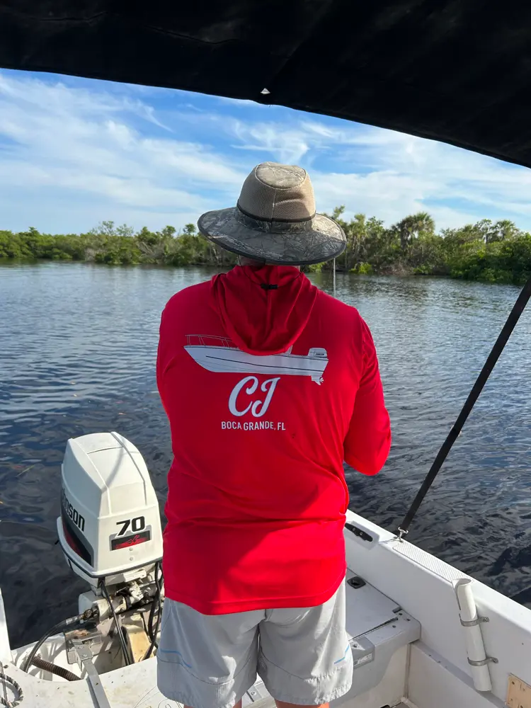 Loves his shirts! An image of a custom yacht shirt cusotmer wearing their apparel on their boat.