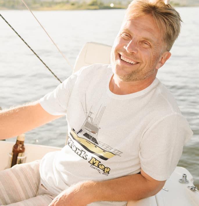 An image of a gentleman on a boat wearing a custom boat shirt.