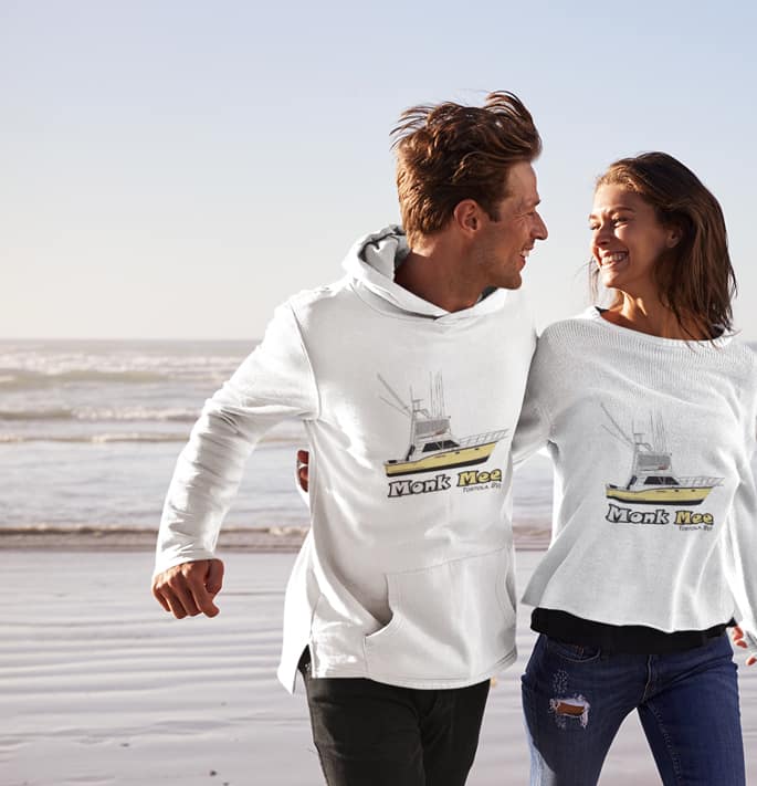 An image of a couple with the husband wearing a custom boat pullover hoodie.
