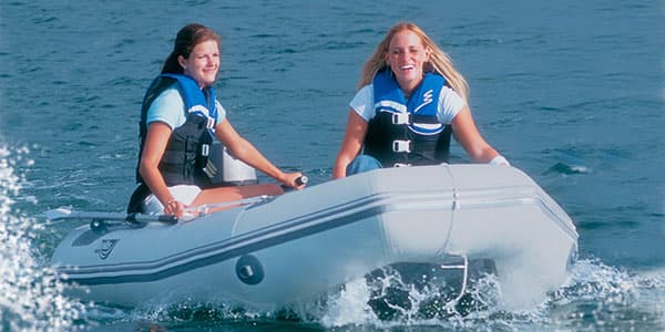 An image of an Achilles inflatable boat with two women inside. 