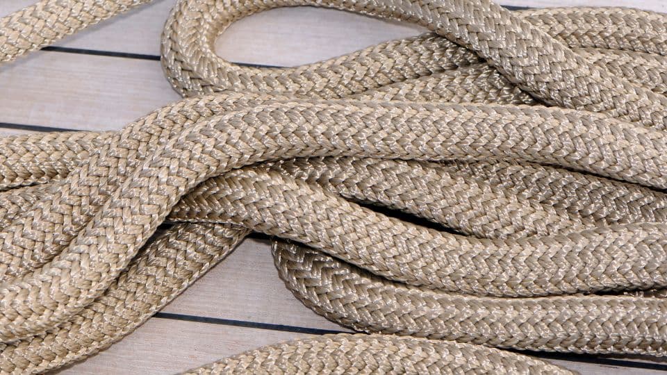 An image of gold colored boat rope on a dock.