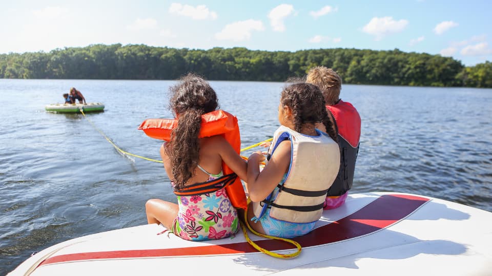 An image of a family on a lake boat with a funny boat name. 