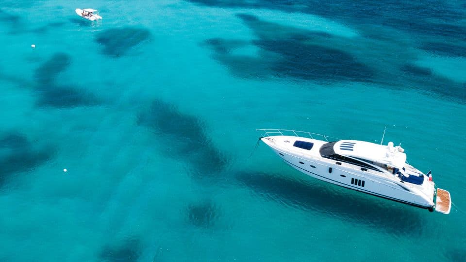 An image of a motoryacht at anchor in beautiful seas. 