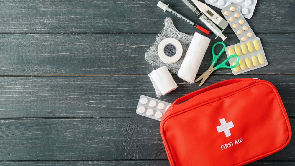 An image of a boat first aid kit and its contents on a dock. 