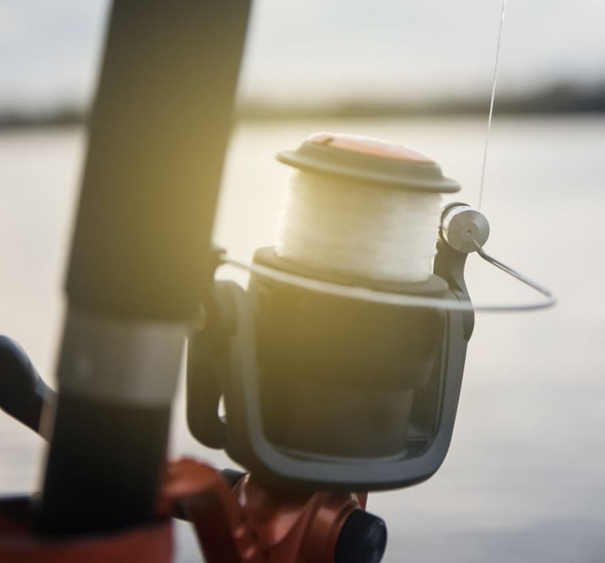 An image of a spinning reel in a rod holder waiting for an angler.