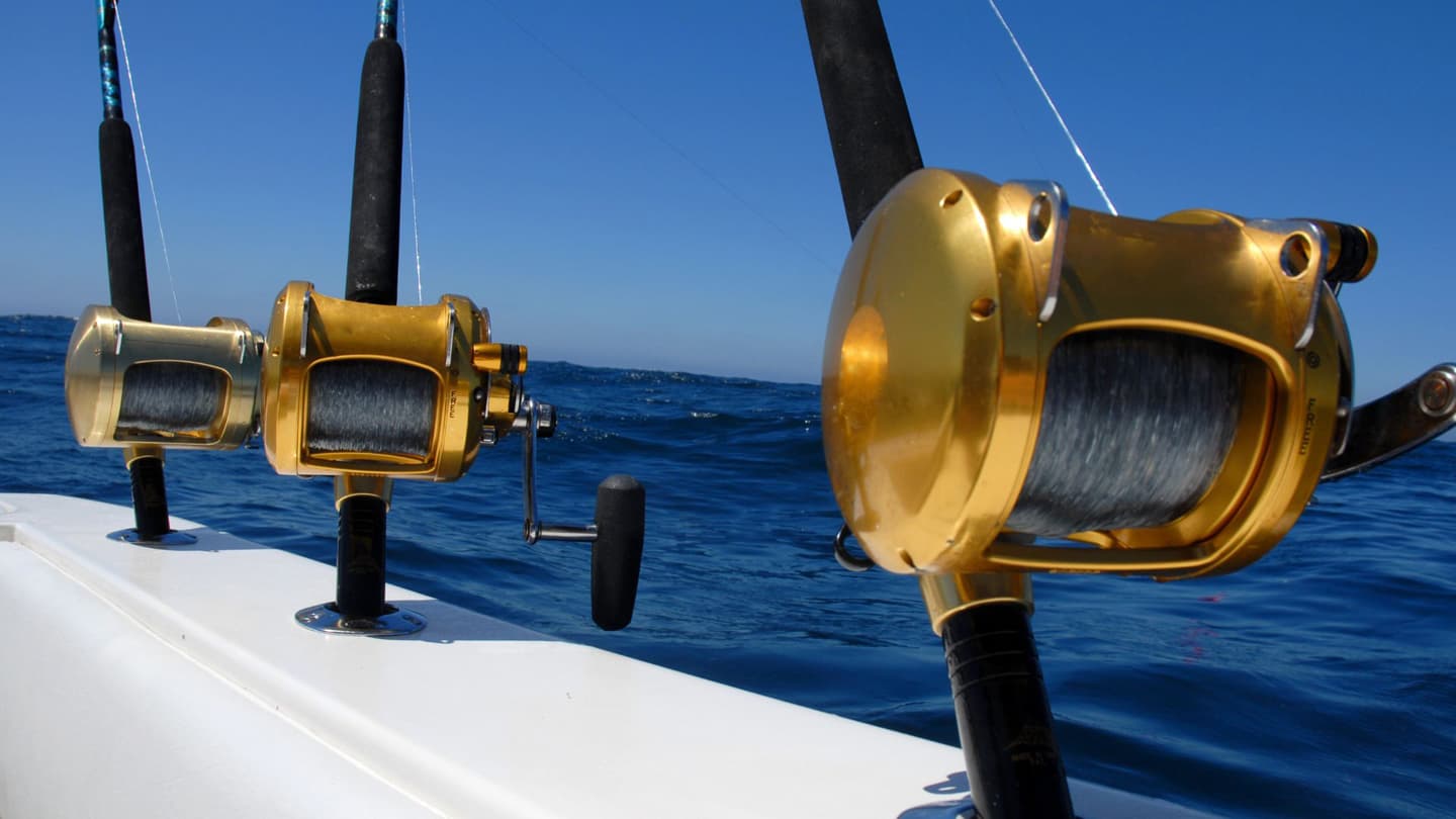 Penn International fishing reels ready for action on a sportsfishing boat in their rod holders. 